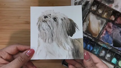 A watercolor portrait of a long-haired Shih Tzu held up to the camera