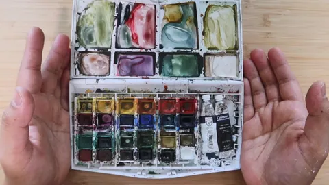 Affordable watercolor supplies laid out on a workspace